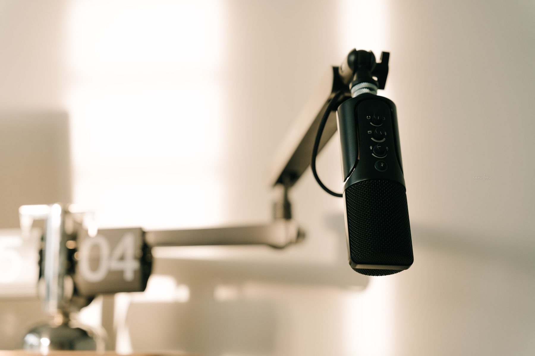 A microphone on a boom arm in a bright studio