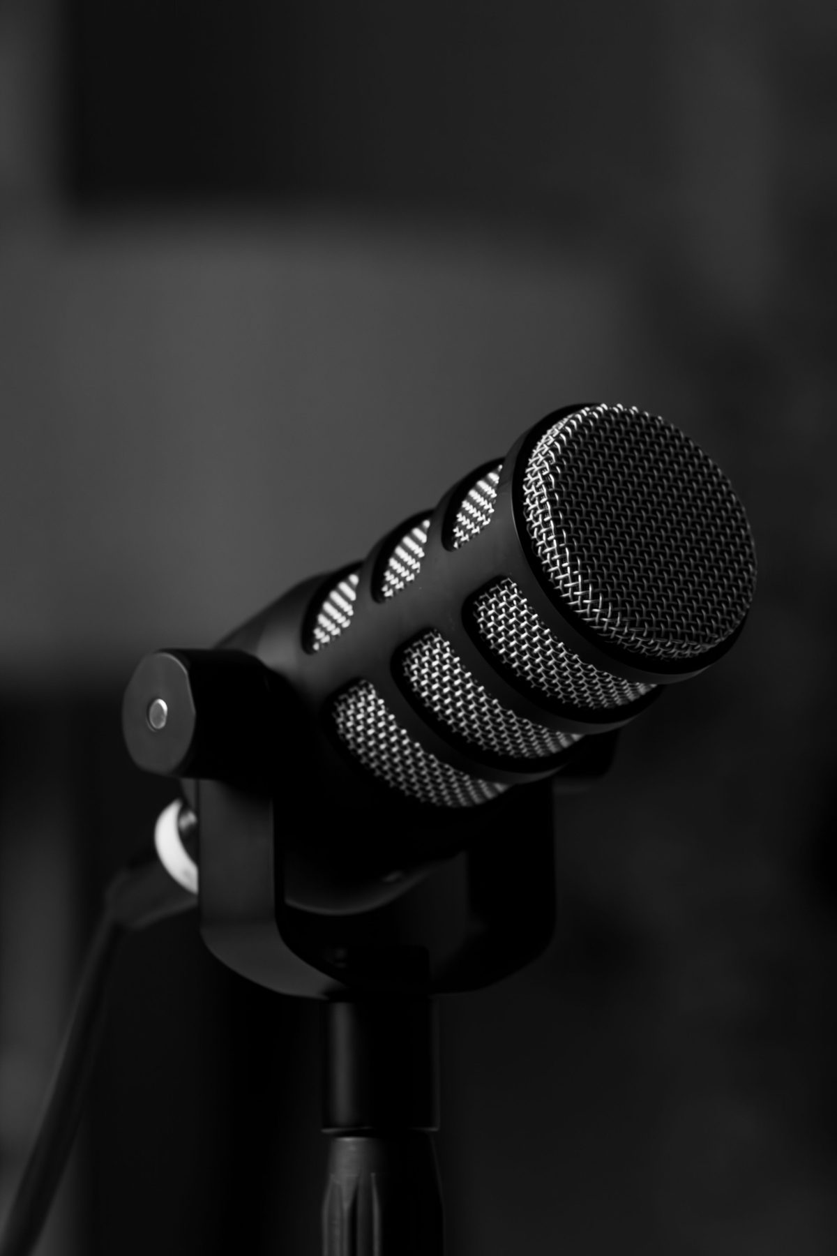 A black and white close-up of a podcast microphone