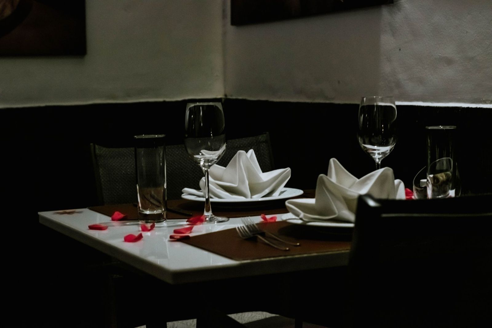A candlelit table laid with rose petals